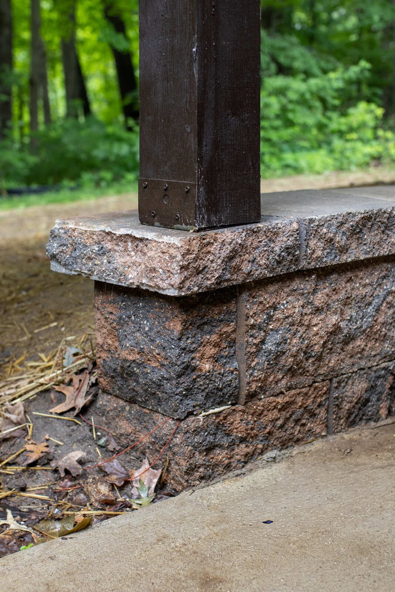 arola custom deck dark post on stone wall corner