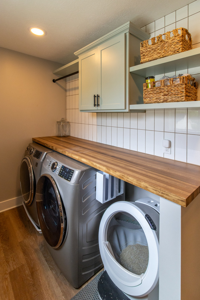 Custom laundry room with wood countertops and white tile backsplash by S. Brown Construction Co. in Bar Barry Heights, IN.
