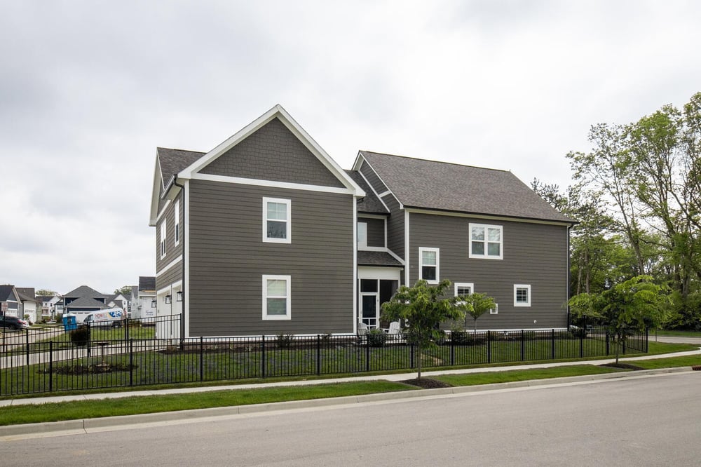 New two-story custom home with dark gray siding and fenced yard in Bar Barry Heights, IN by S. Brown Construction Co.