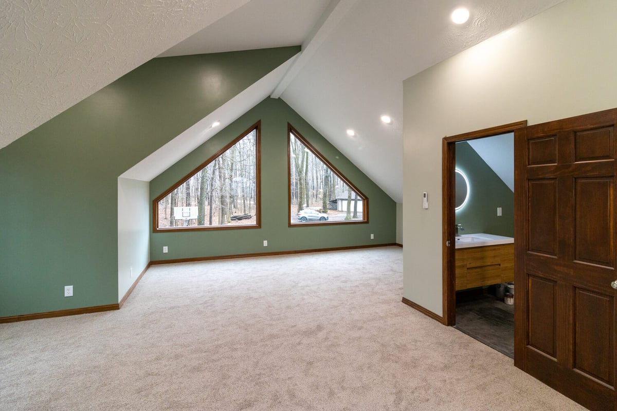 Vaulted ceiling room with green accent walls and forest views built by S. Brown Construction Co. in Wildcat Creek, IN.