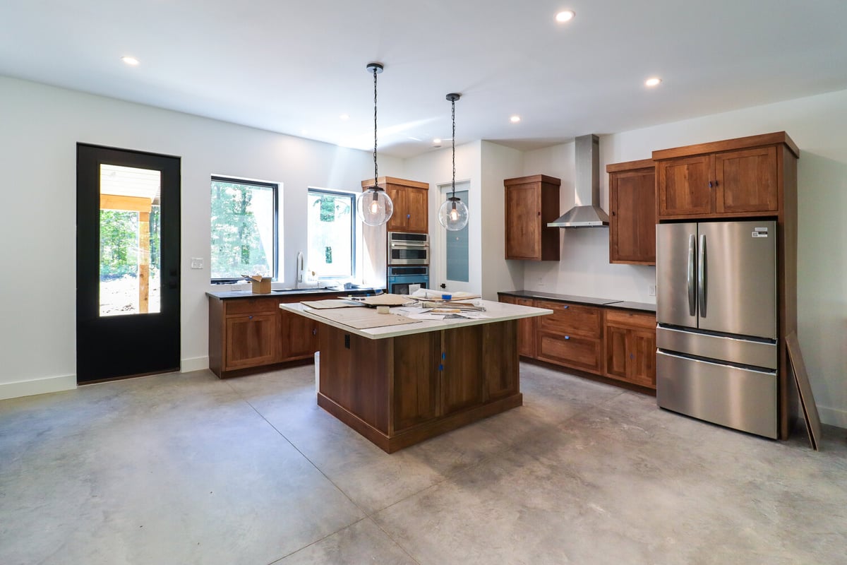 Open-concept barndo kitchen featuring wood island and stainless appliances by S. Brown Construction Co. in Raineybrook, IN.