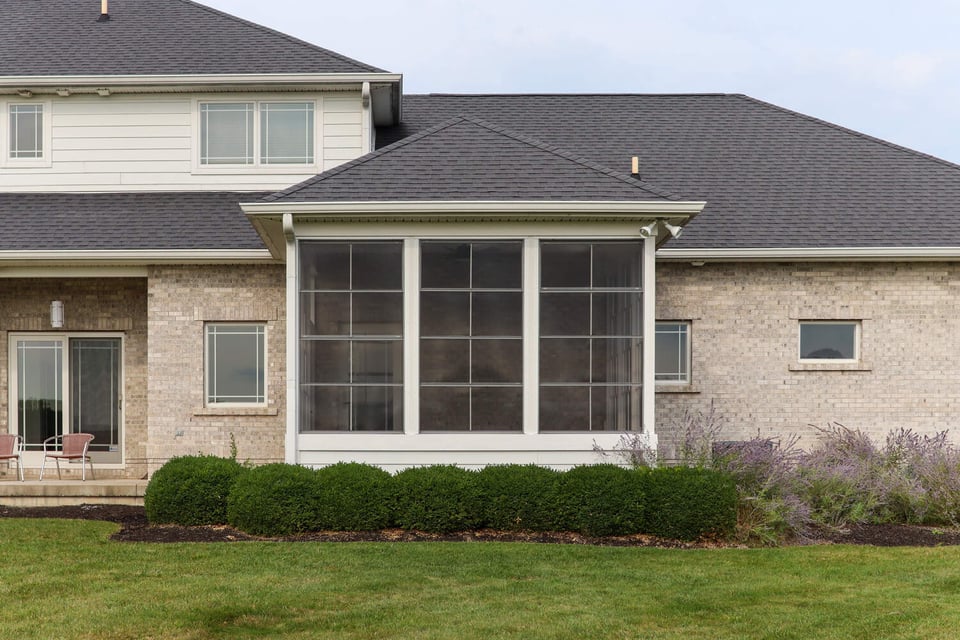 Elegant screened porch addition with large windows and brick siding by S. Brown Construction Co., Raineybrook, IN.