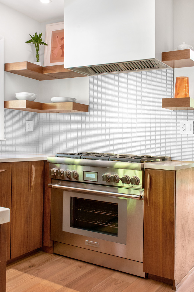Mid-century style custom kitchen in Buck Creek, IN with floating shelves and Thermador range by S. Brown Construction Co.