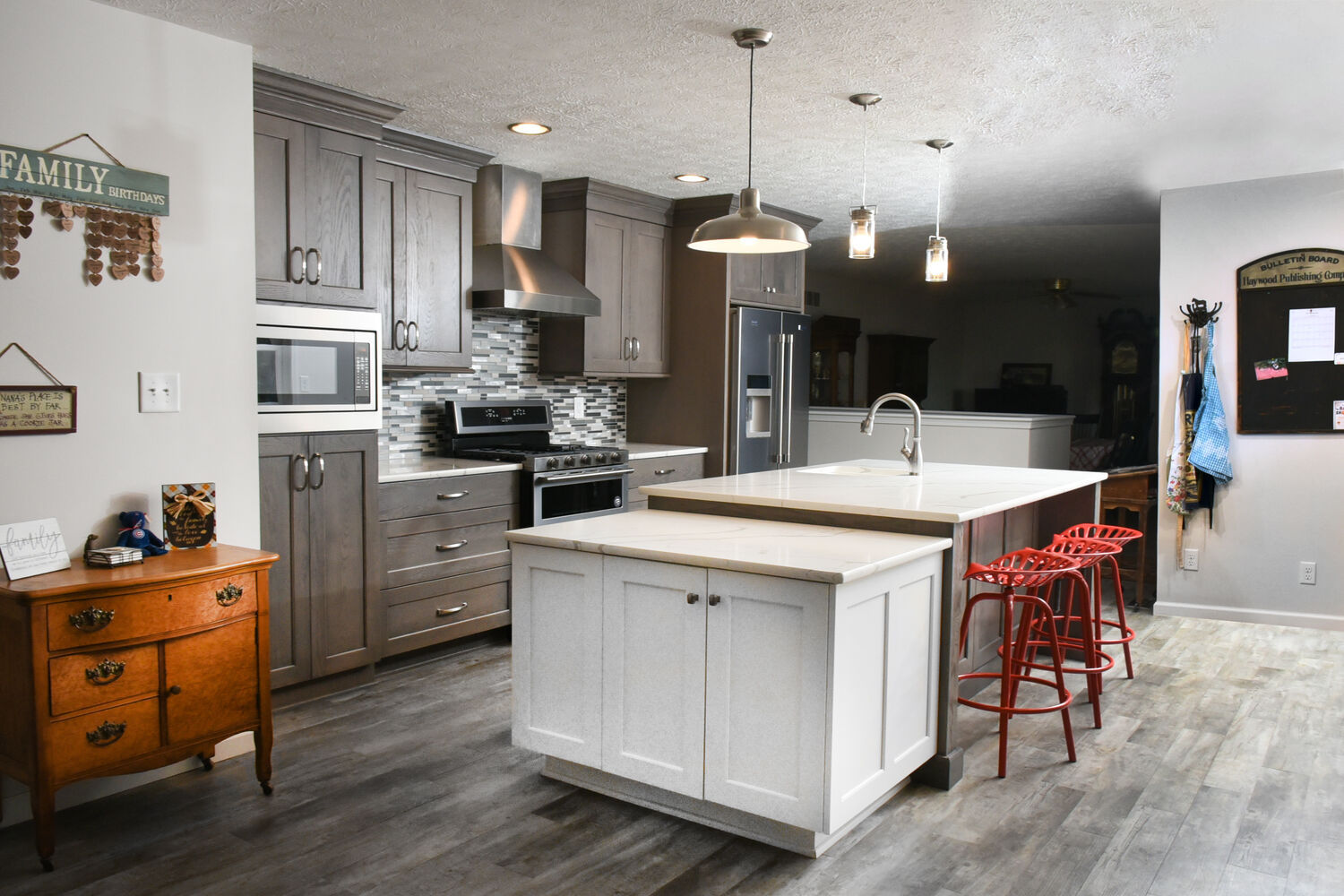 Open concept kitchen renovation by S. Brown Construction Co. in Bar Barry Heights, IN featuring a white island and tile backsplash.
