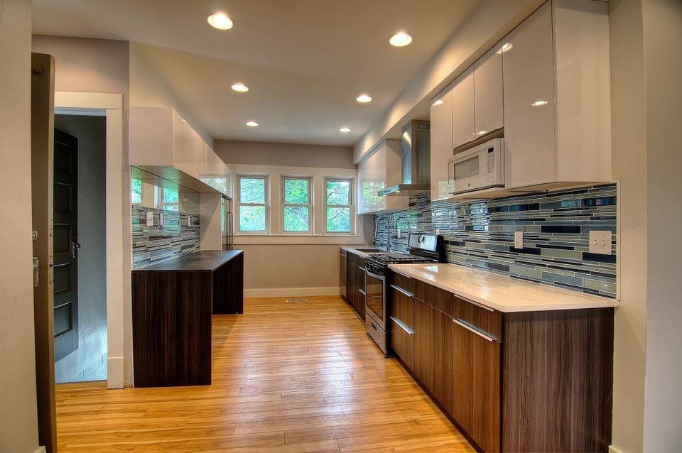 Contemporary galley kitchen with high-gloss cabinets and custom backsplash by S. Brown Construction Co. in Lafayette, IN.