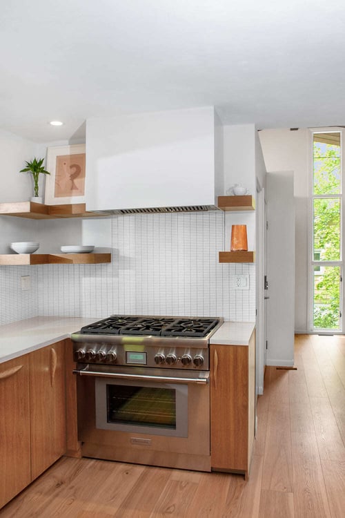 Airy kitchen remodel in Lafayette with custom cabinets and range hood