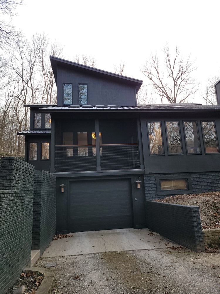 Unique multi-level black home design in wooded setting by S. Brown Construction Co. in University Farm, IN.