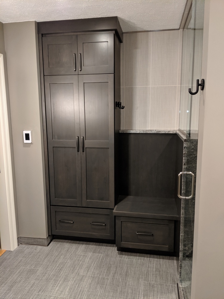 Dark custom cabinetry and built-in bench in modern bathroom by S. Brown Construction Co. in Wildcat Creek, IN.