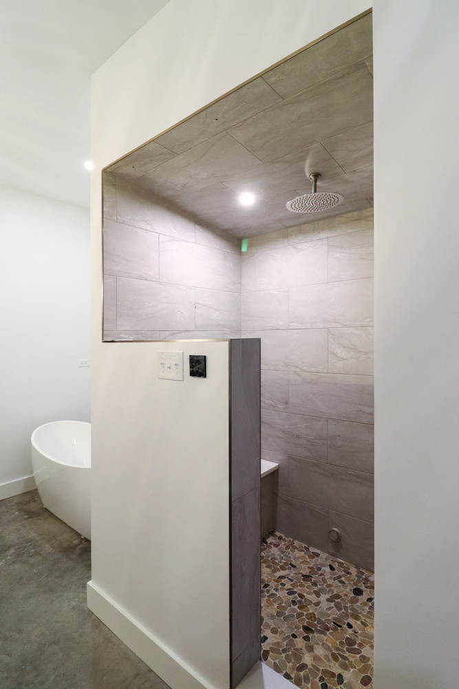 Open tile walk-in shower with natural stone floor designed by S. Brown Construction Co. in Raineybrook, IN.