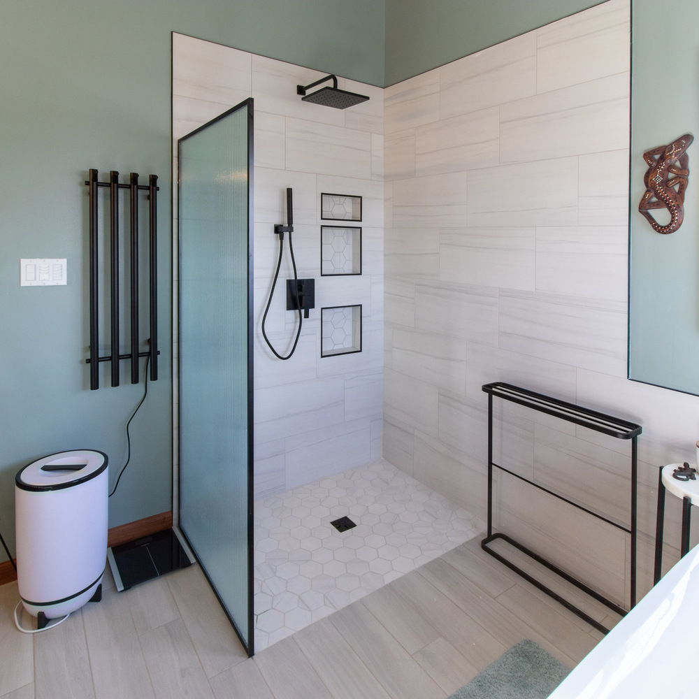 Walk-in tile shower with frosted glass divider and matte black fixtures in Raineybrook, IN by S. Brown Construction Co.
