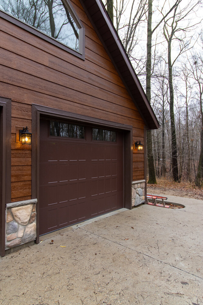 Custom garage exterior with wood-grain siding and stone trim, built by S. Brown Construction Co. in University Farm, Indiana.