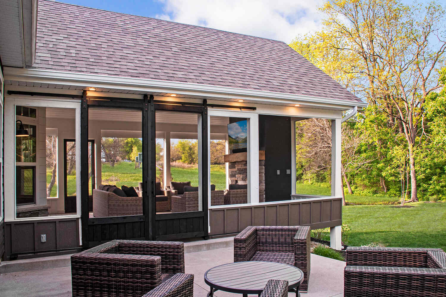 Custom outdoor living room with screened walls and a stone fireplace, built by S. Brown Construction Co. in Wildcat Creek, IN.