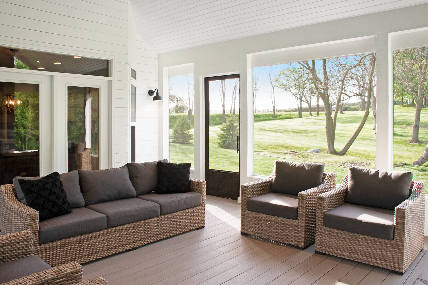 Neutral-toned screened porch with shiplap walls and views of a landscaped backyard, created by S. Brown Construction Co., Indiana.