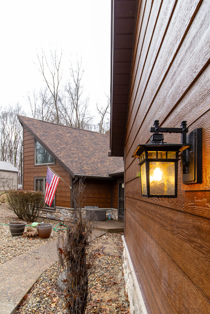 Rustic home exterior with rich wood siding and modern lantern lighting by S. Brown Construction Co., serving Bar Barry Heights, IN.