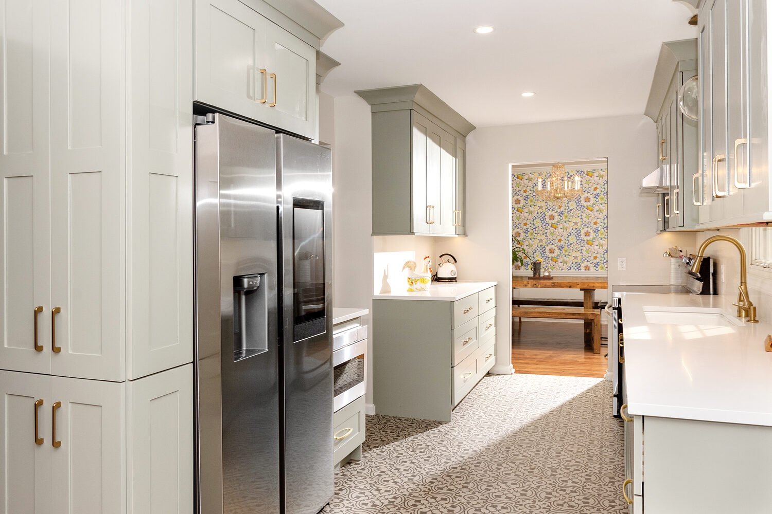 Elegant galley kitchen remodel with gold hardware and patterned flooring by S. Brown Construction Co. in Lafayette, IN.