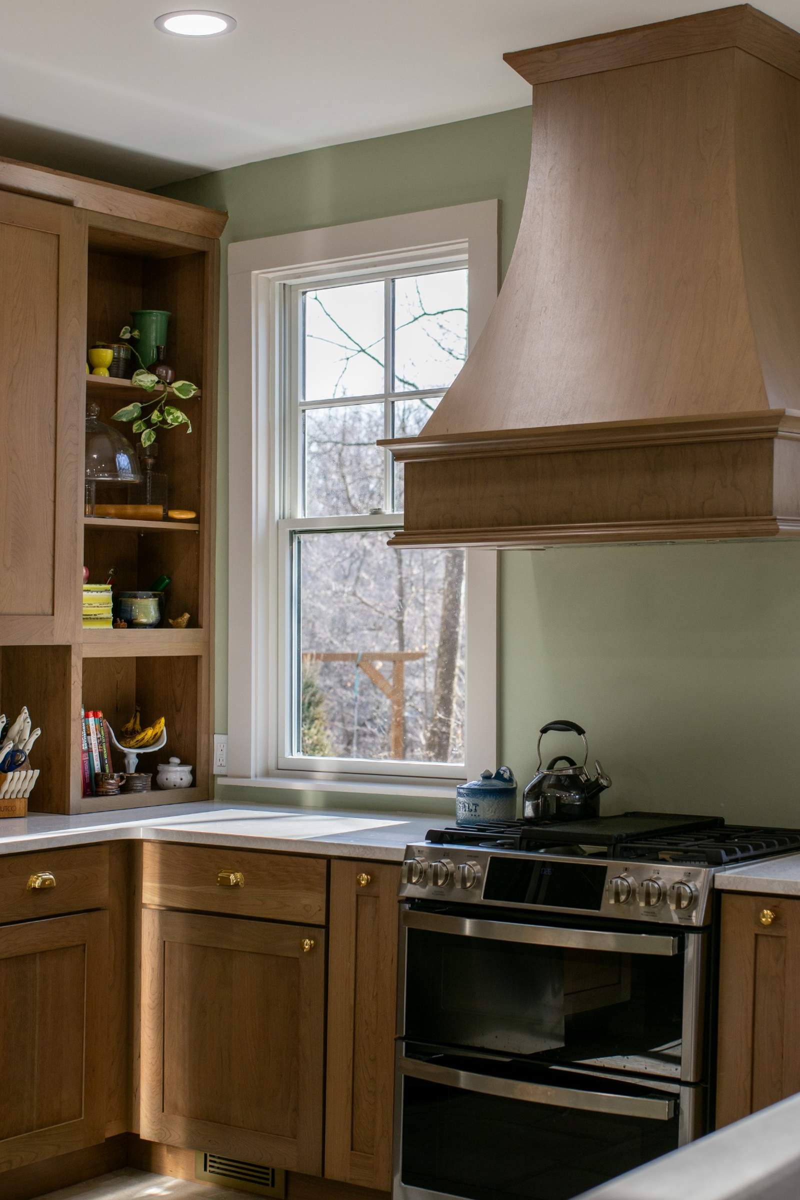 Kitchen design with wood hood and window lighting in Lafayette, IN by S. Brown Construction Co.