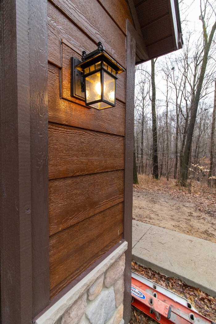 Decorative exterior wall lantern mounted on stained wood siding in the Schoon Garage Addition by S. Brown Construction Co. in La-optimized