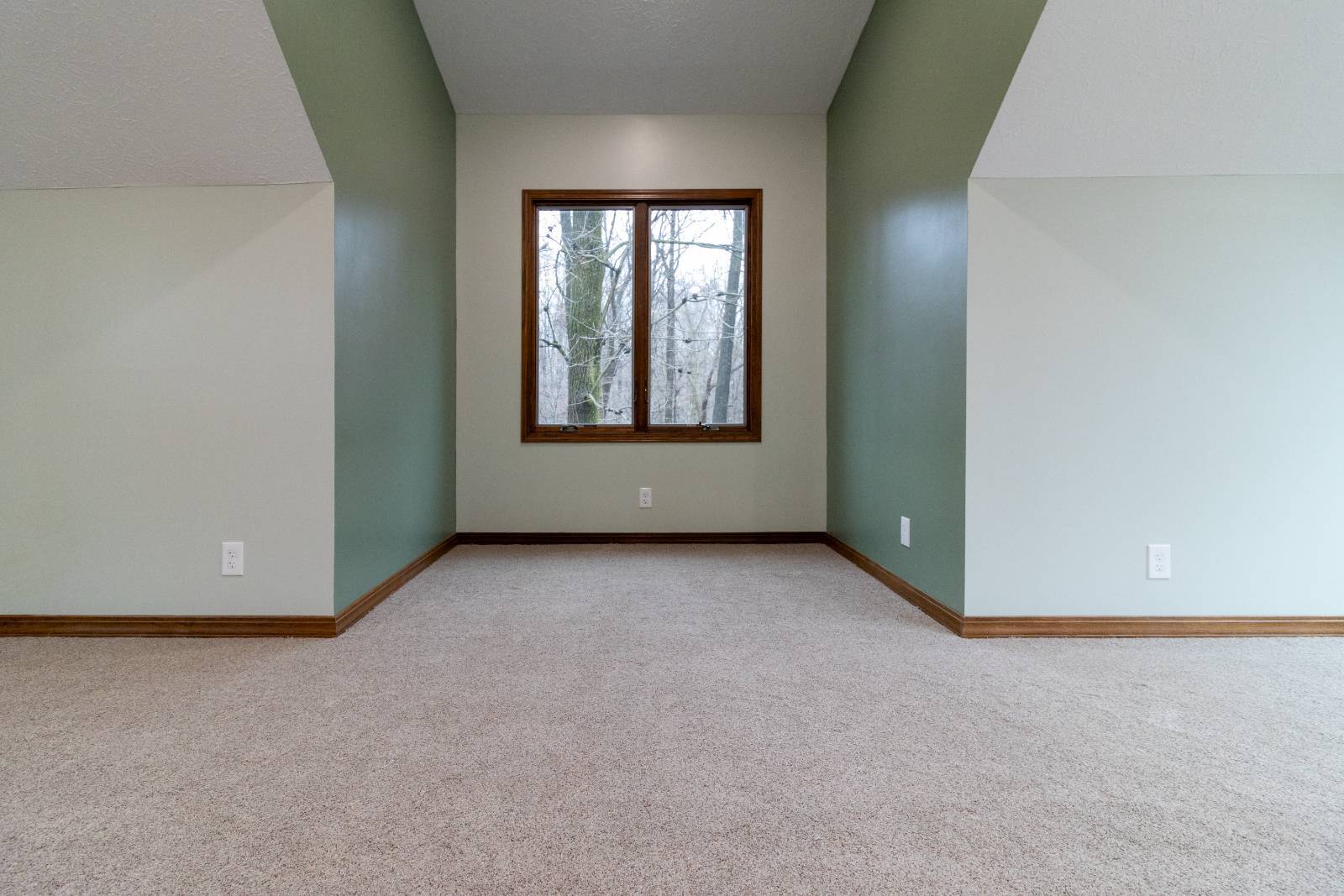 S. Brown Construction Co. Schoon Garage Addition upper-level living space with recessed window seating area and forest views in -optimized